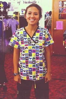 a nurse wearing a colorful scrubs shirt adorned with hearts