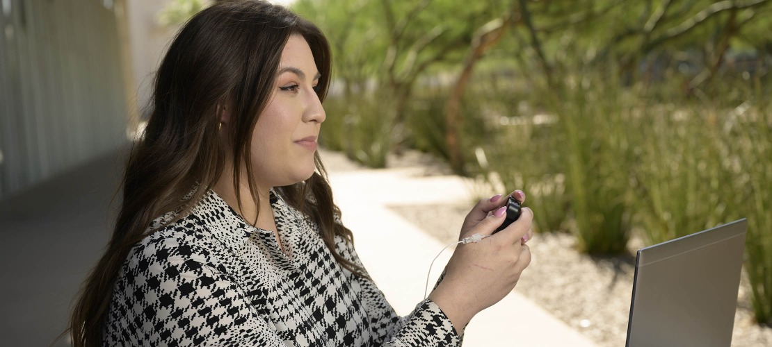 A College of Medicine – Phoenix medical student with Type 1 diabetes using a glucose monitor on herself